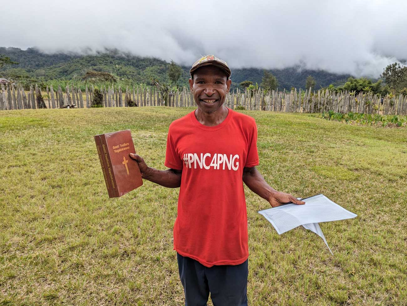 Smiling man in Papua New Guinea holds up his new Bible.